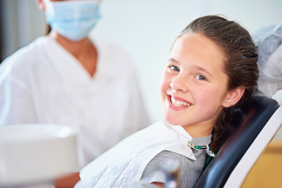 A child smiling before their dental procedure